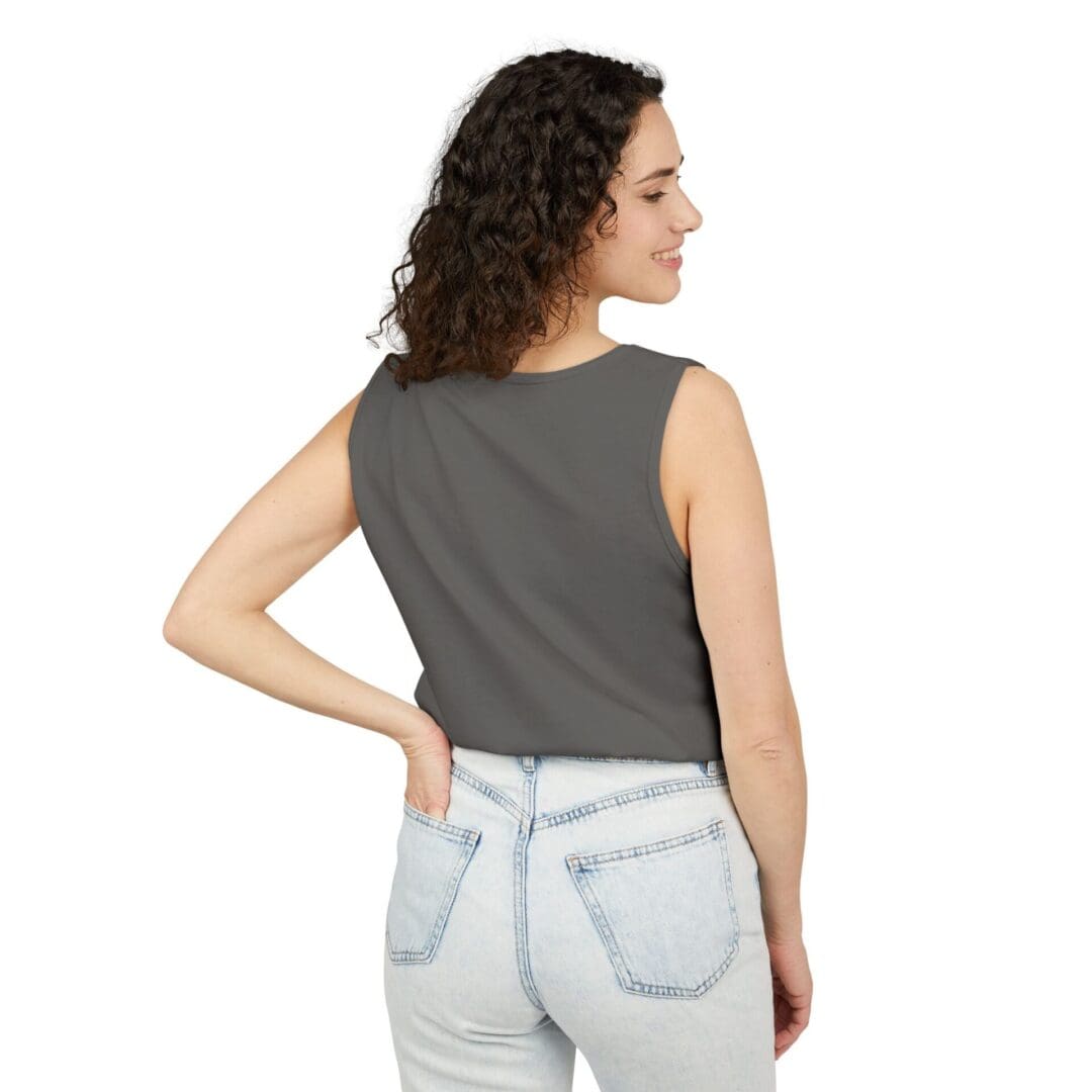 Woman in a gray sleeveless top and light jeans, facing away.