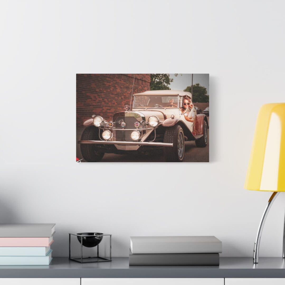 Vintage car photo mounted on a white wall above a modern desk setup.