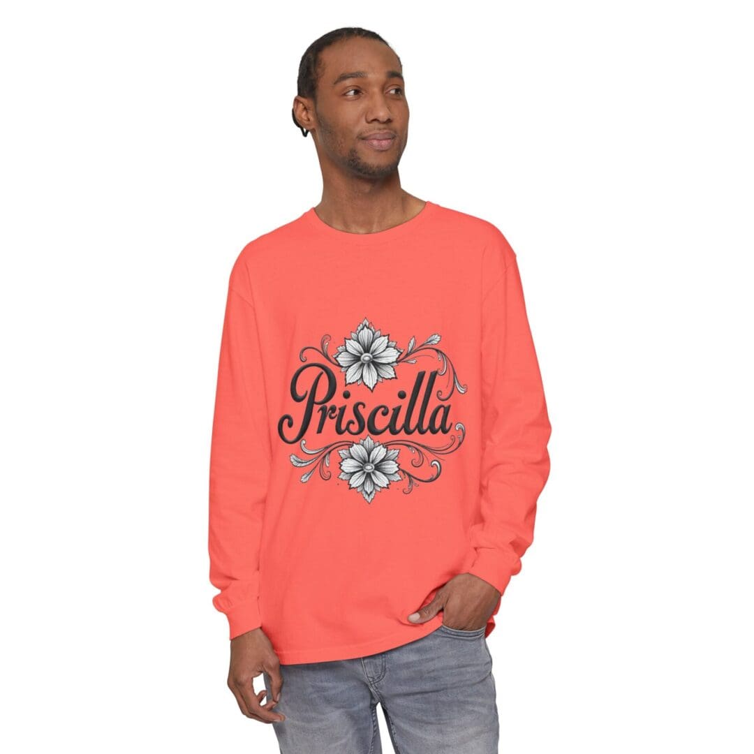 Man wearing a coral sweatshirt with floral design and 'Priscilla' text.