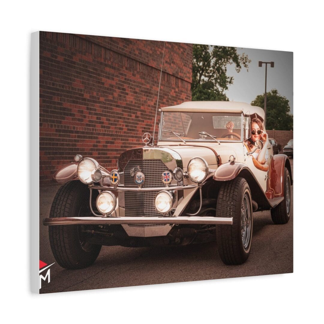 A vintage car parked on a street near a brick wall.