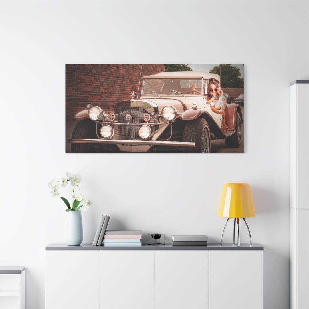 Vintage car artwork above a modern white sideboard with decor.