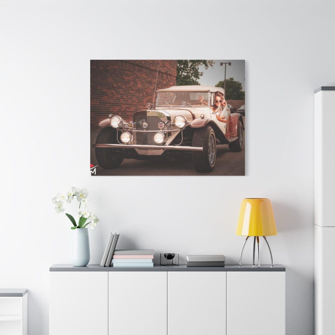 Vintage car artwork hanging above a modern sideboard with decor.