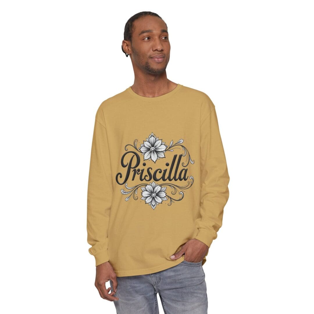 Man wearing a mustard yellow sweatshirt with 'Priscilla' and floral graphics.
