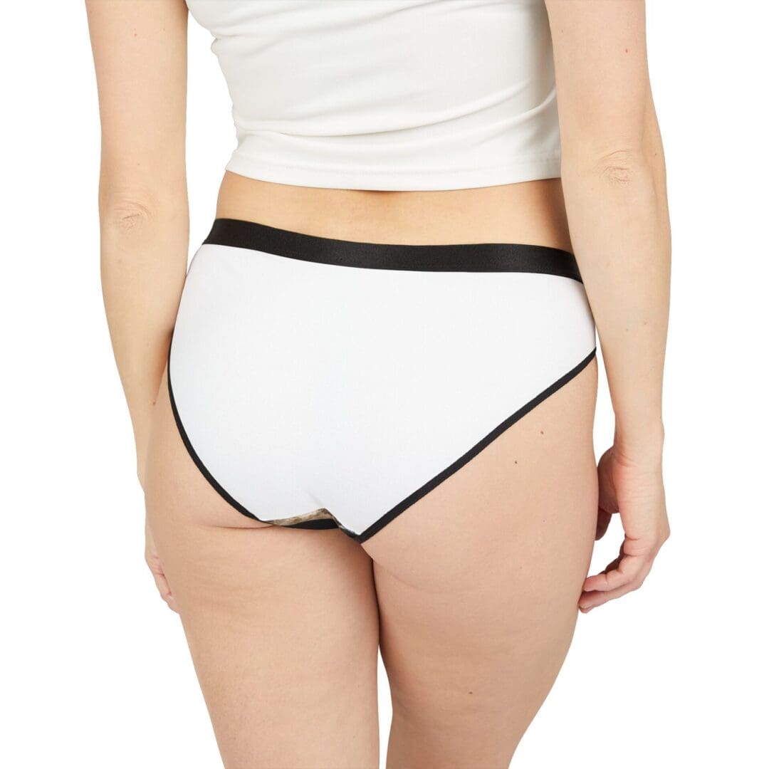 Woman wearing white high-waisted underwear with black trim.