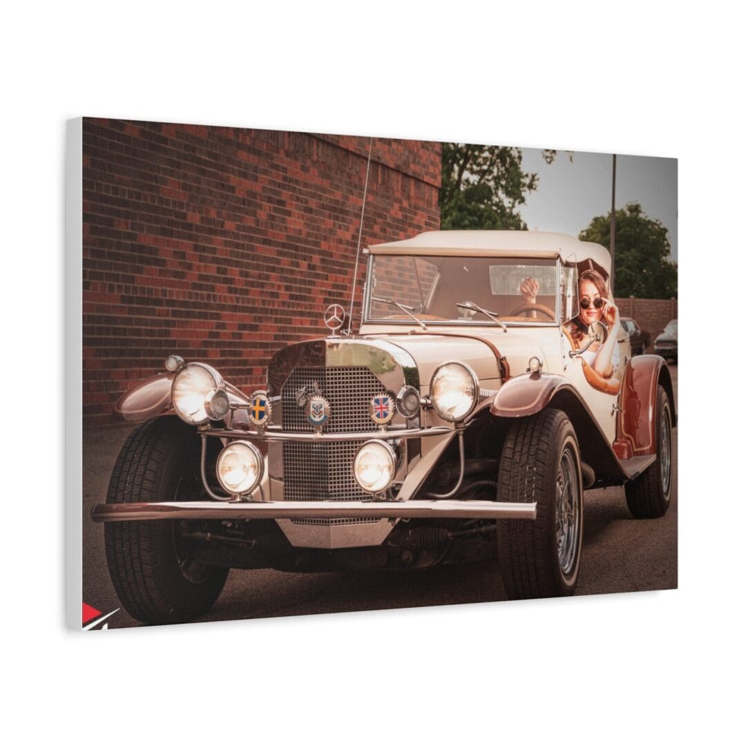 Vintage car with a driver and passenger on a street.