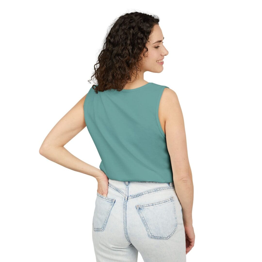 Woman wearing a sleeveless teal top and light blue jeans, viewed from the back.