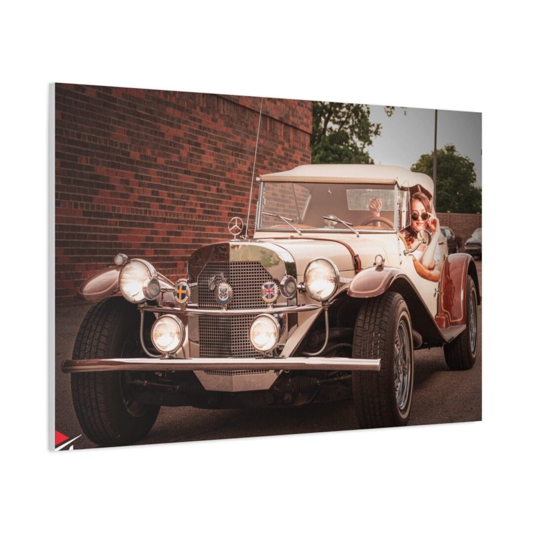 Vintage car with a driver and passenger on a street.