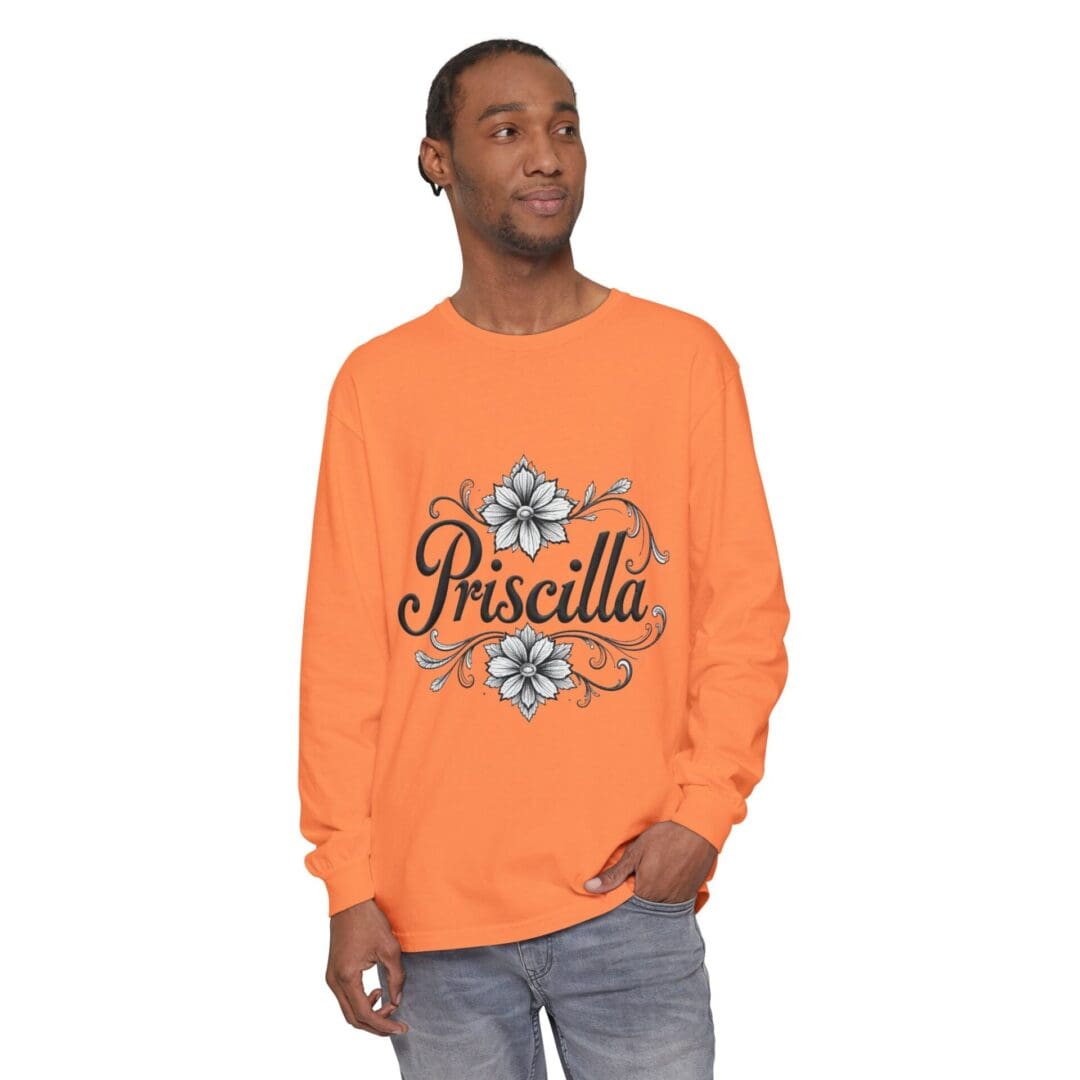 Man wearing an orange sweatshirt with "Priscilla" and floral design.