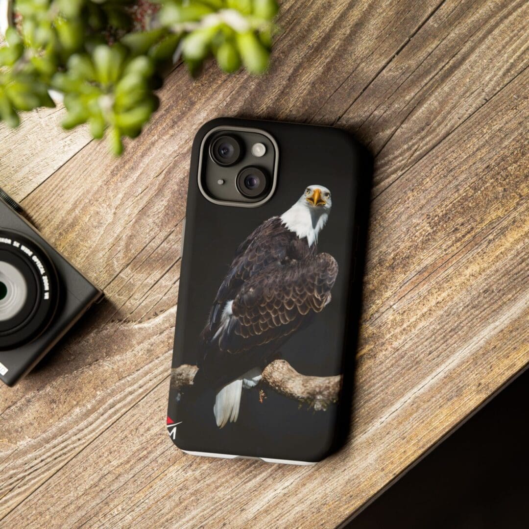 Black phone case with a bald eagle perched on a branch design.