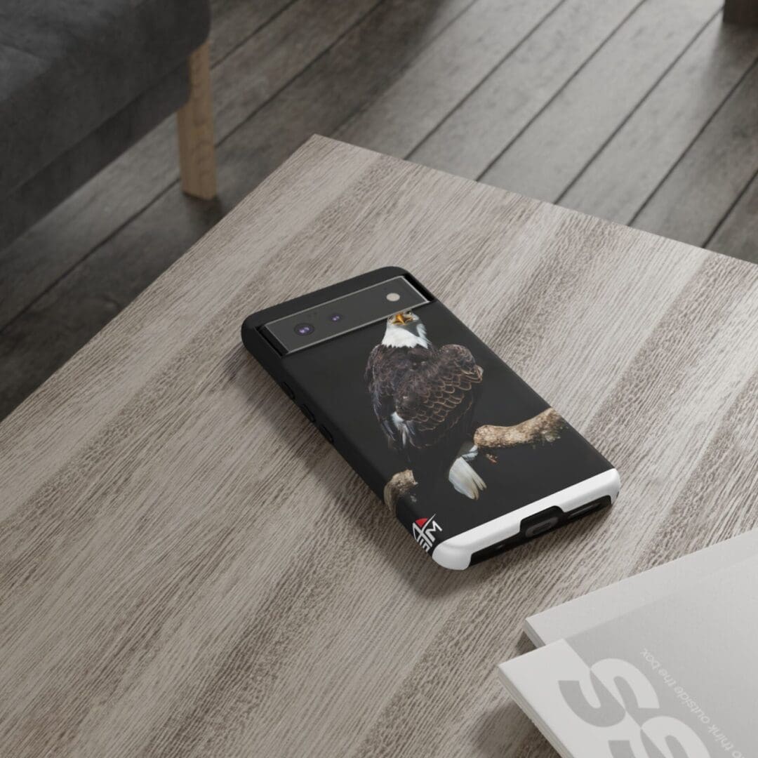Smartphone with a black and white case on a wooden table.