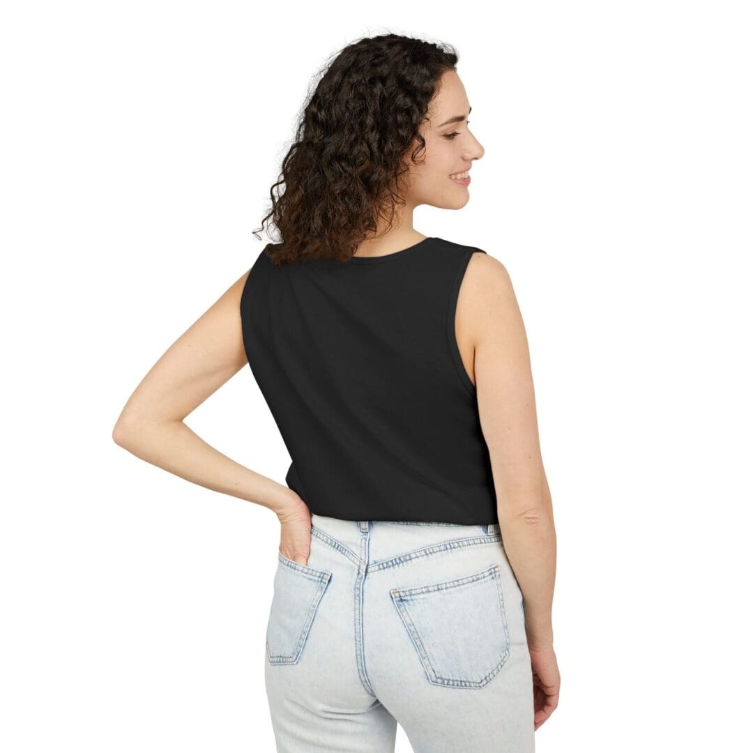 Woman in black sleeveless top and light blue jeans, back facing the camera.