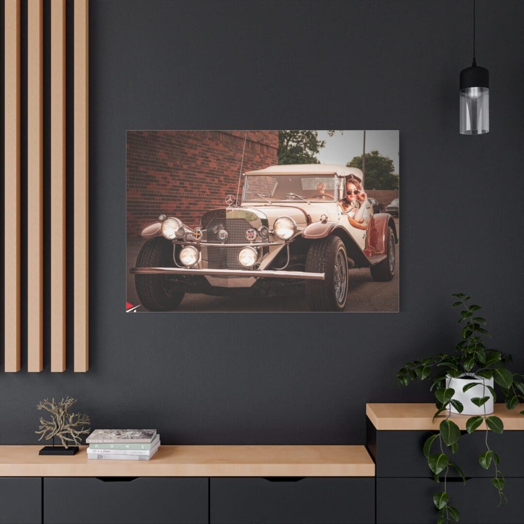 Vintage car photograph hanging on a modern dark wall above a workspace.