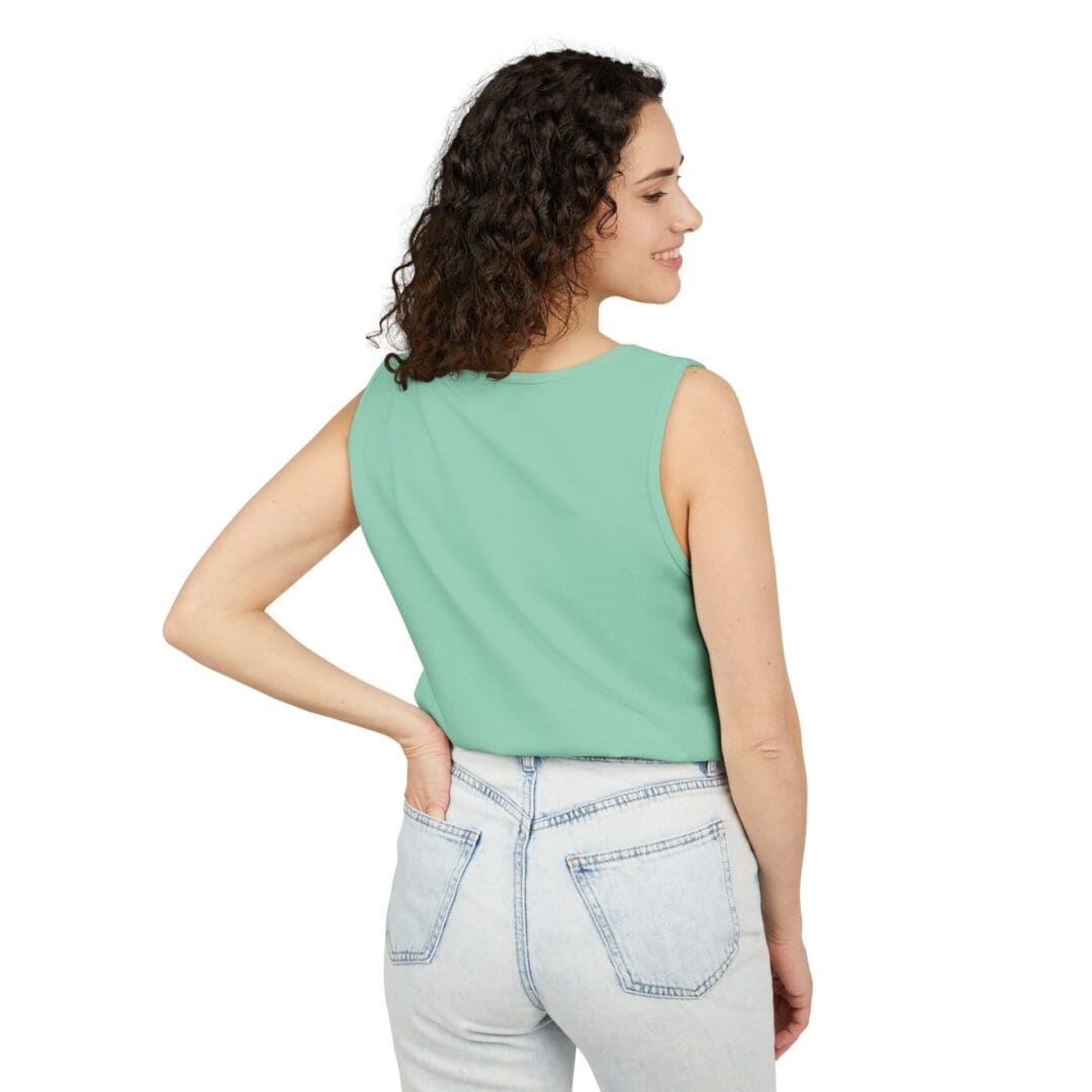 Woman in a sleeveless green top and light blue jeans, facing away.