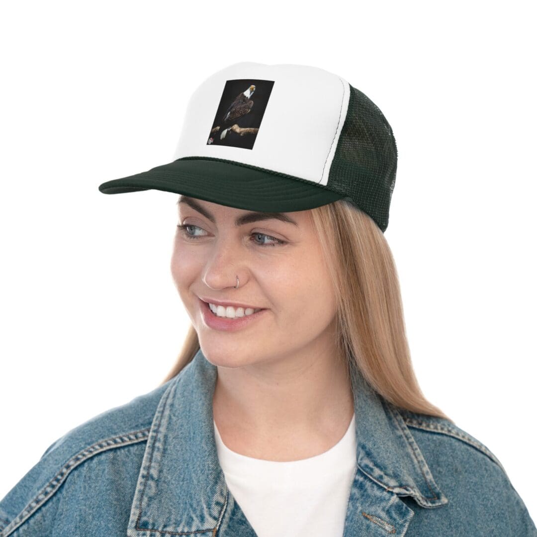Smiling woman wearing a green and white cap and denim jacket.