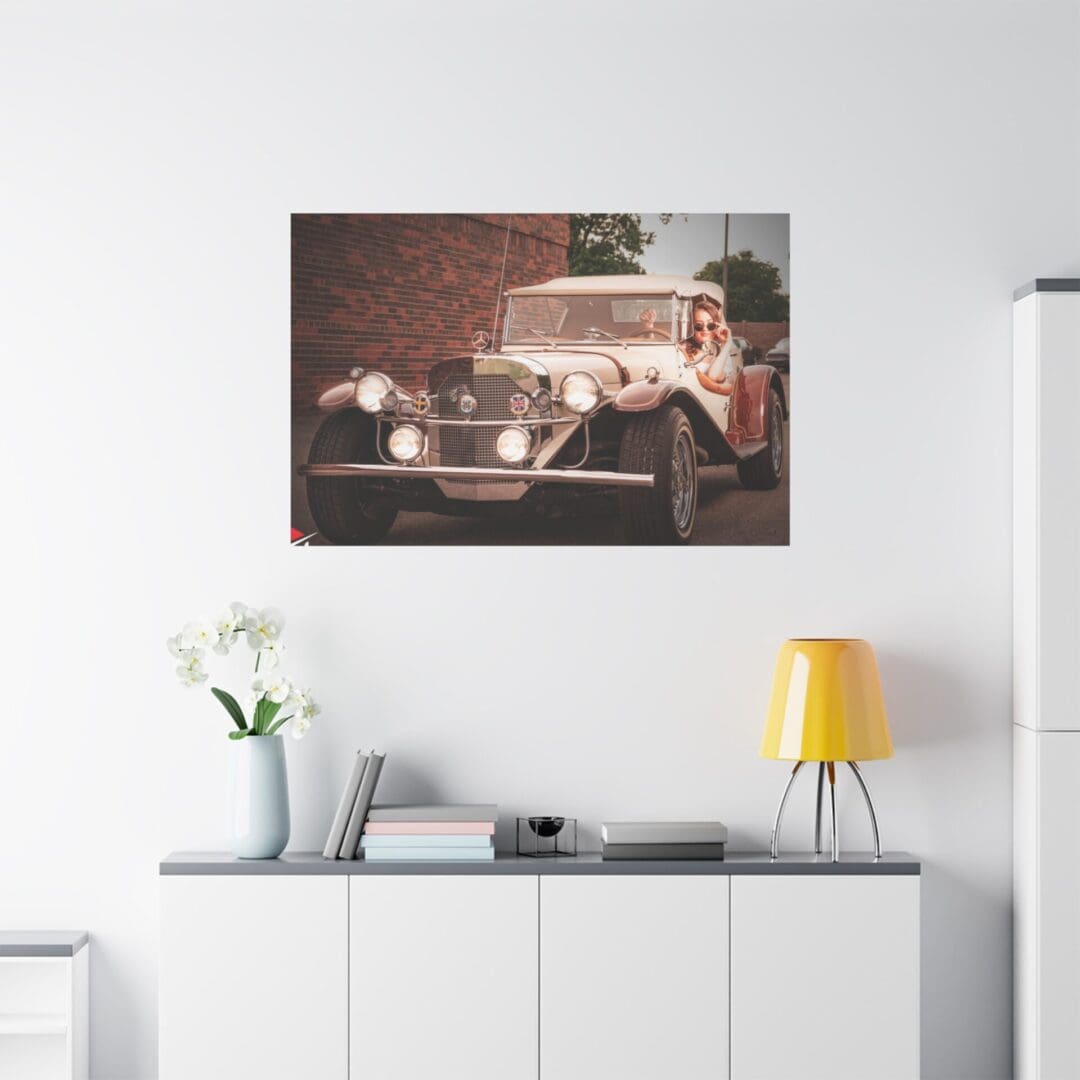 Vintage car artwork hanging above a modern white sideboard with decor.