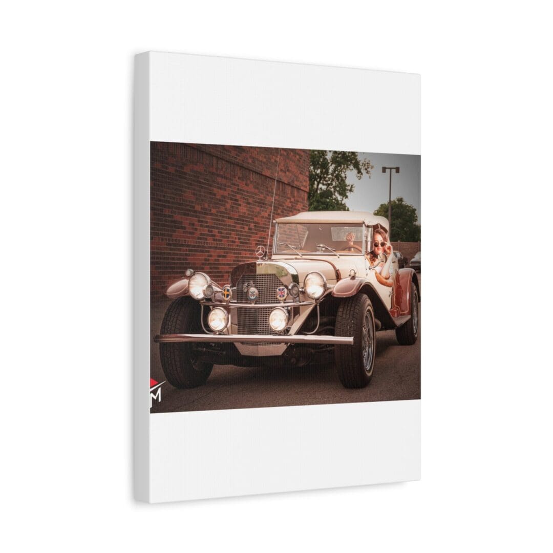 A vintage car parked near a brick wall with greenery in the background.