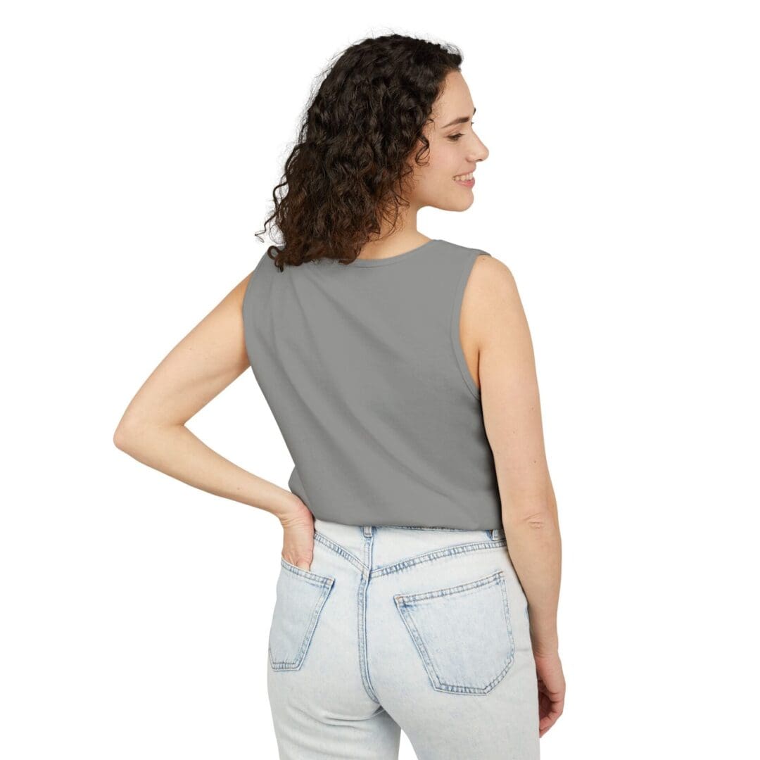 Woman in a gray sleeveless top and light jeans, facing away.