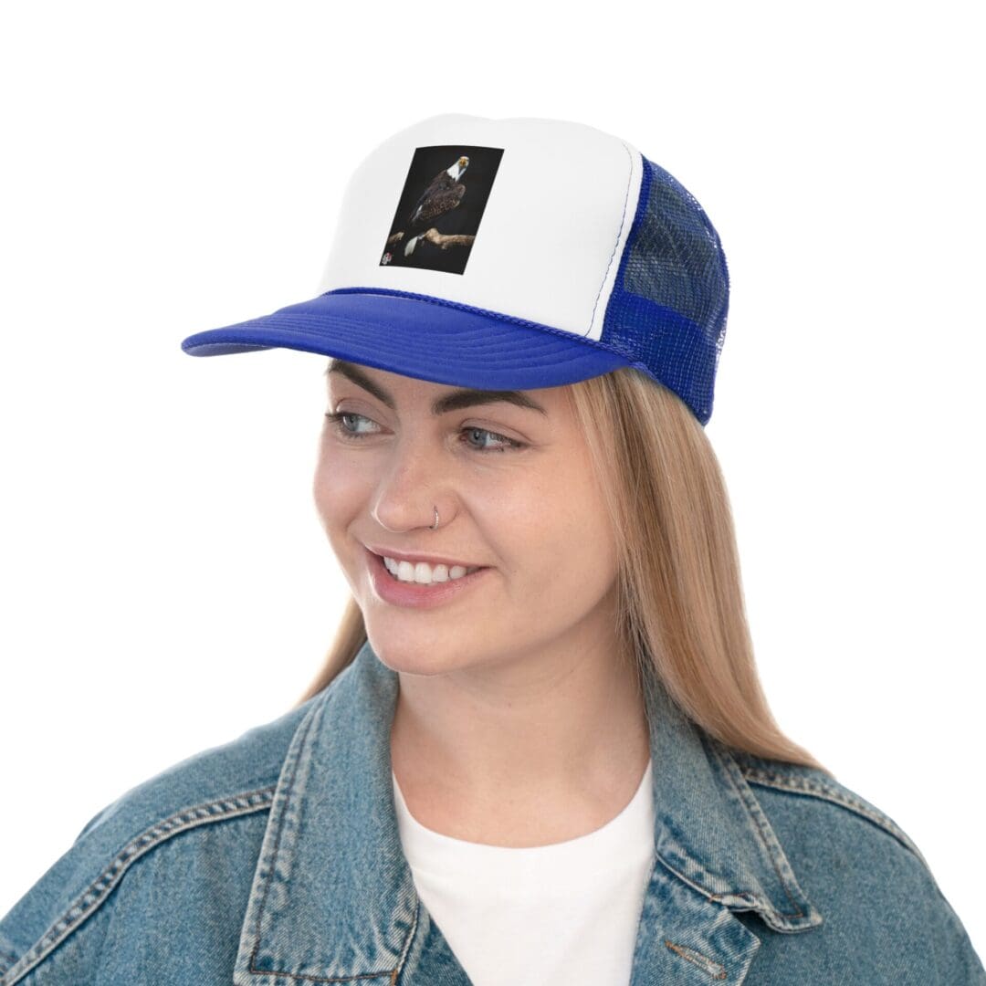 Young woman smiling, wearing a blue and white cap and denim jacket.