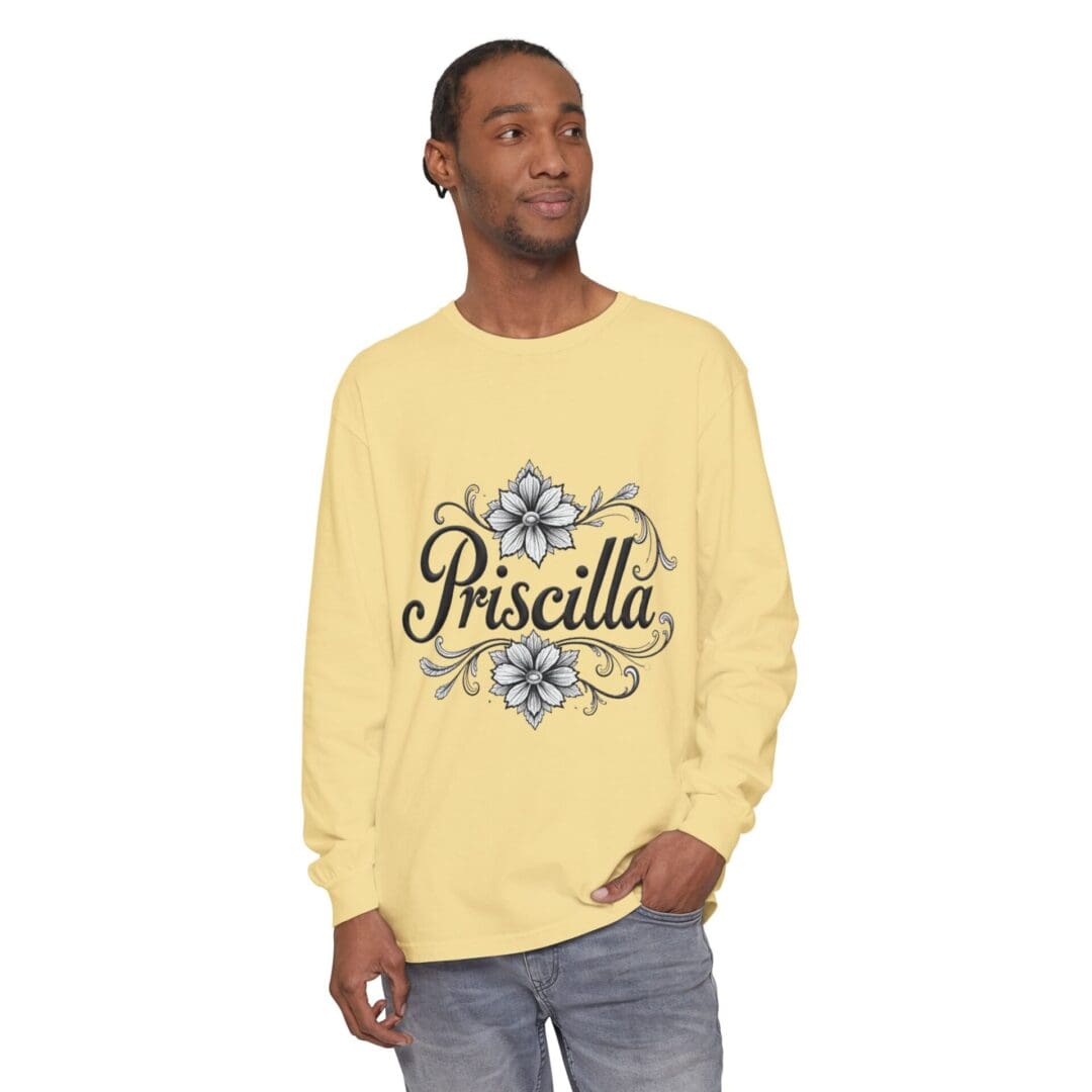 A man wearing a yellow long-sleeve shirt with 'Priscilla' text and floral design.
