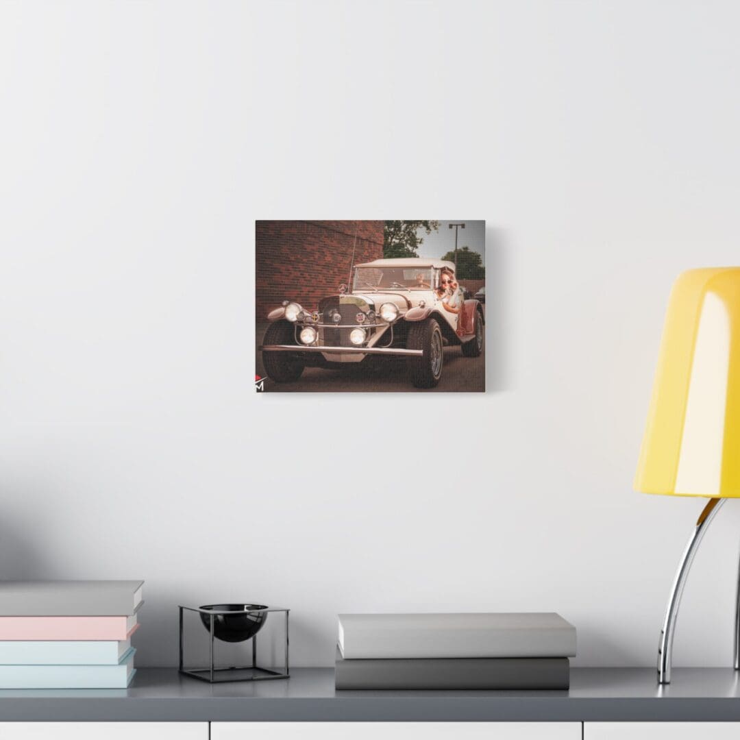 Vintage car photo hanging on a white wall above a desk with modern decor.