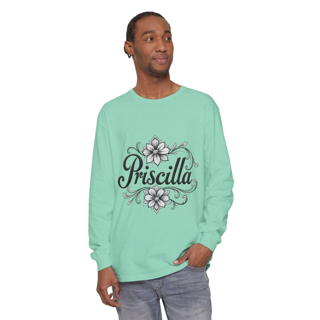 Man wearing a mint green sweatshirt with 'Priscilla' and floral design.