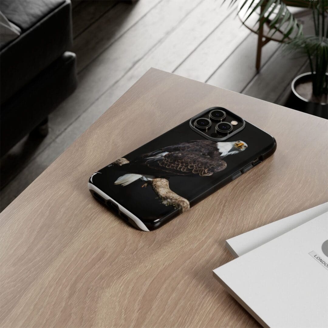 Stylish black marble-patterned phone case on a wooden desk.