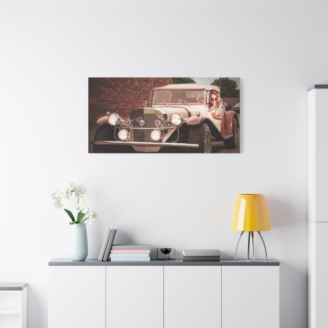 Vintage car artwork above a modern sideboard with decor.