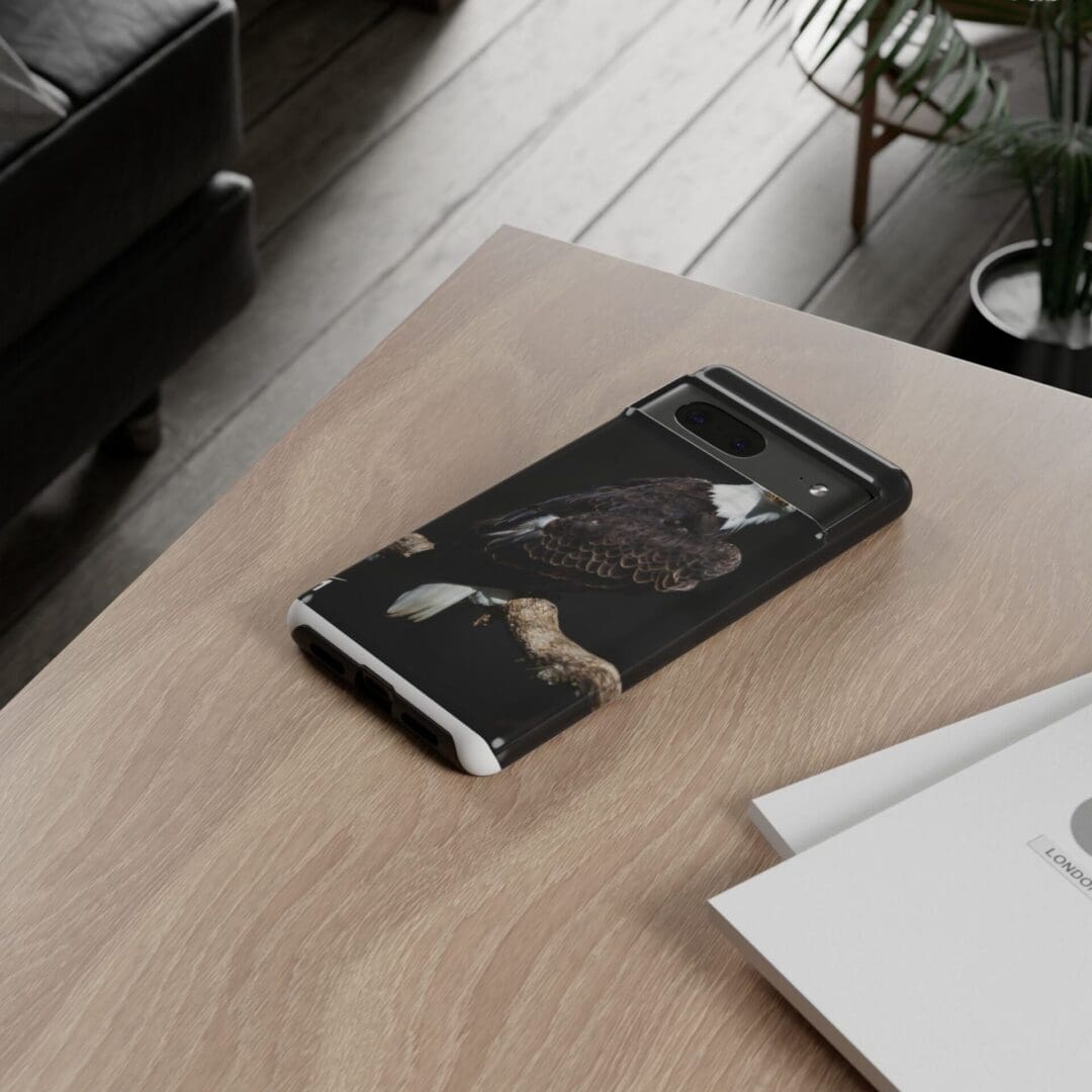 A black marble-patterned smartphone case on a wooden table.