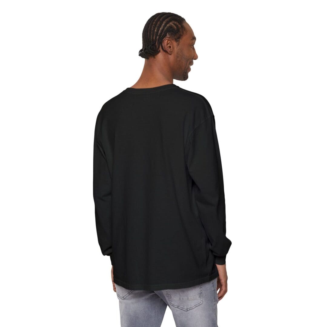 Man wearing a loose black long-sleeve shirt and light gray pants, facing away.