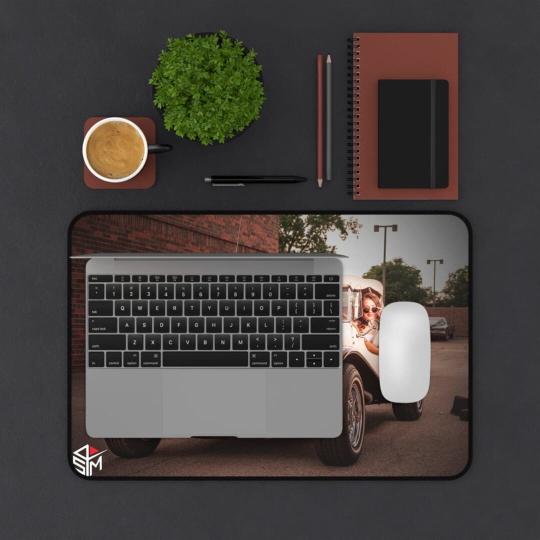 A neatly arranged workspace with a laptop, coffee, plant, and notebook.