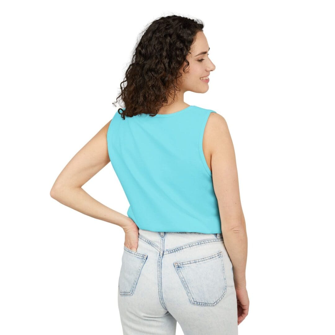 Woman in a turquoise sleeveless top and light jeans, facing away.