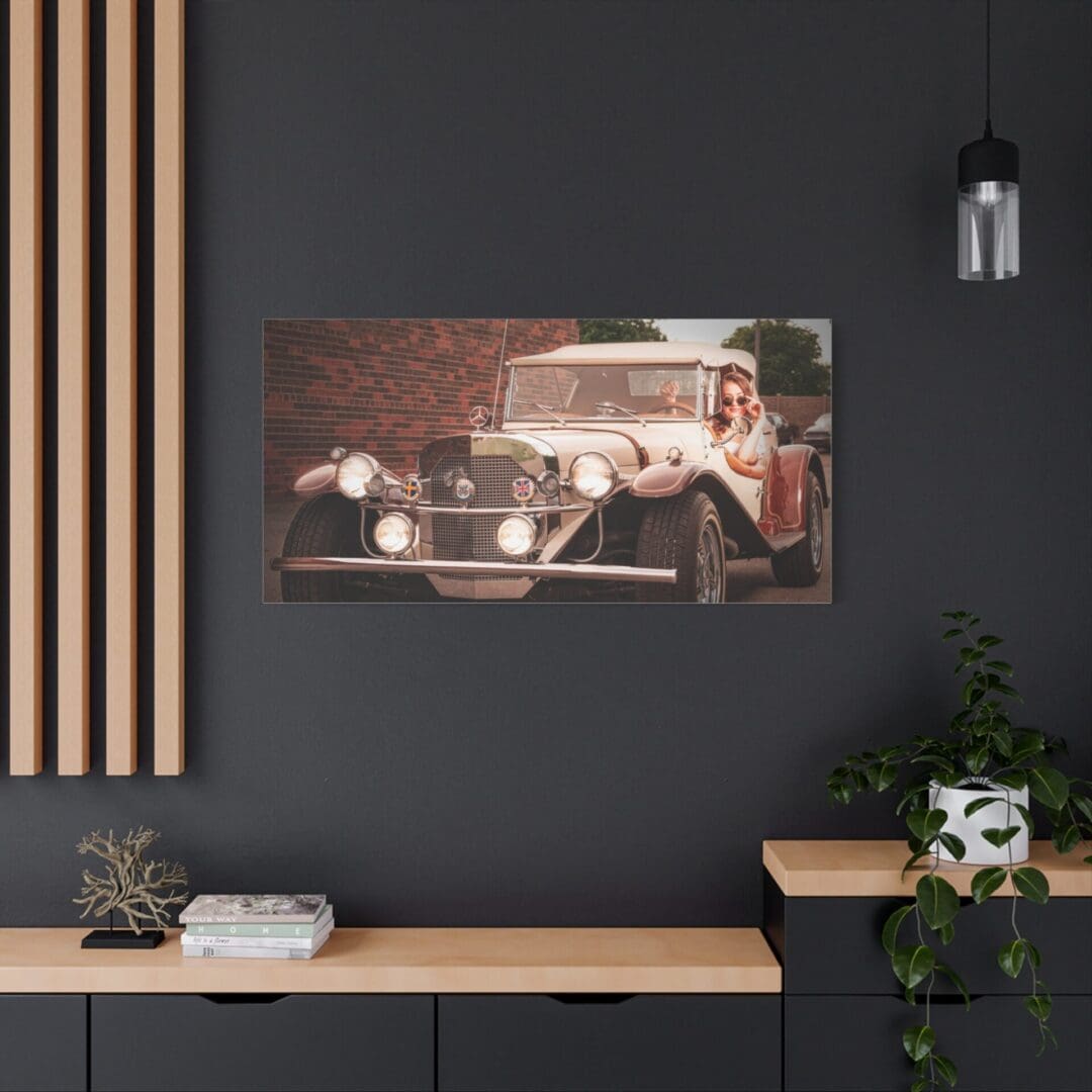 Vintage car artwork on a modern black wall above a minimalist desk setup.