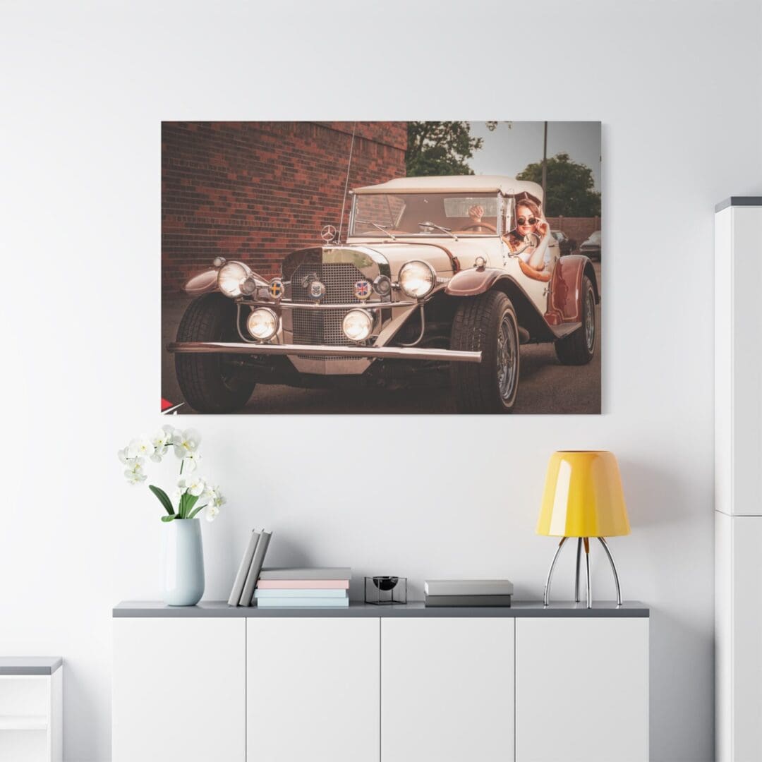 Vintage car artwork hung above a modern white sideboard with decor.