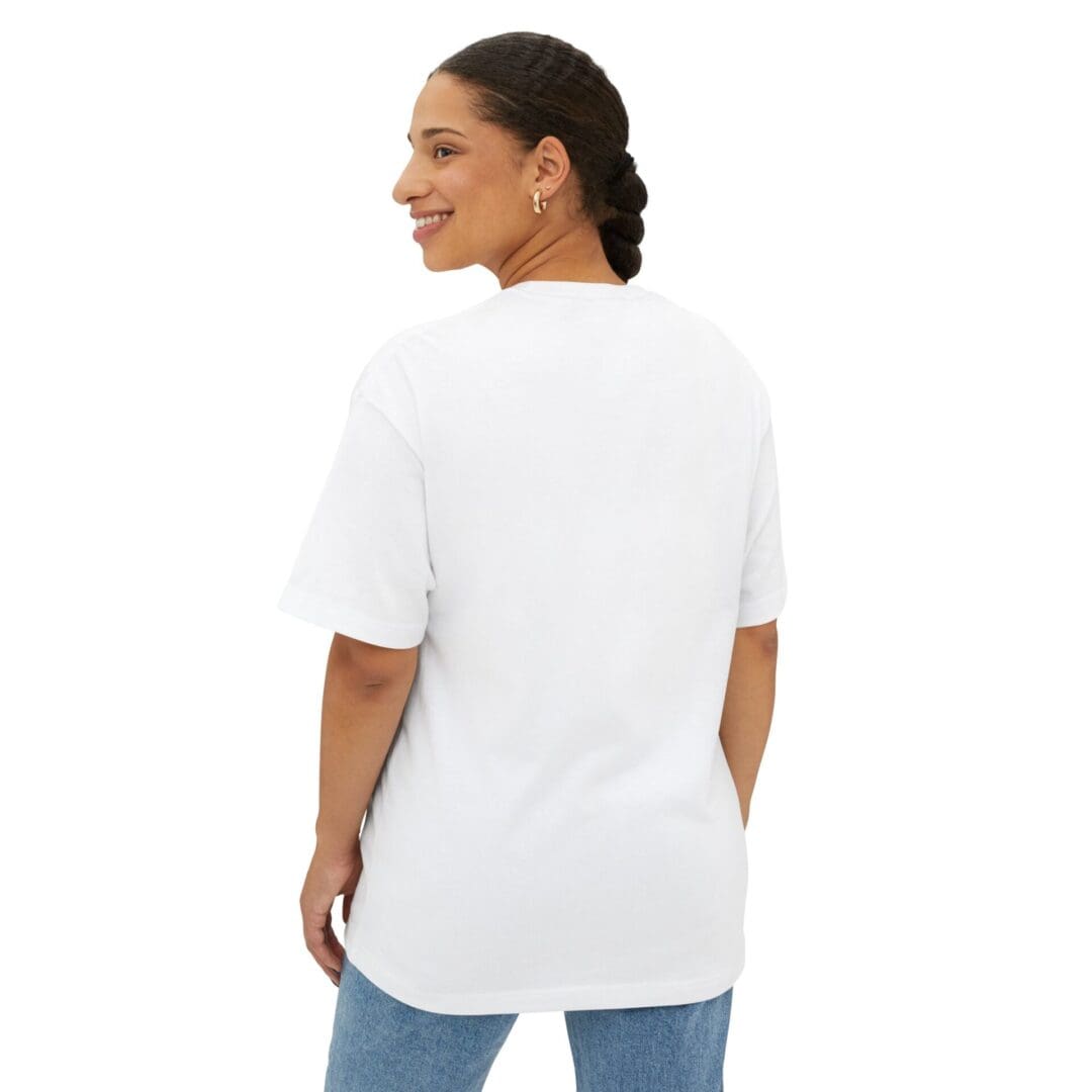 Woman smiling, wearing a plain white oversized T-shirt and blue jeans, facing away.