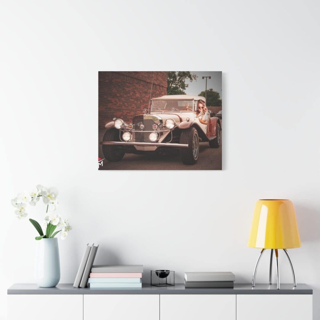 Vintage car artwork above a modern white console with decor.